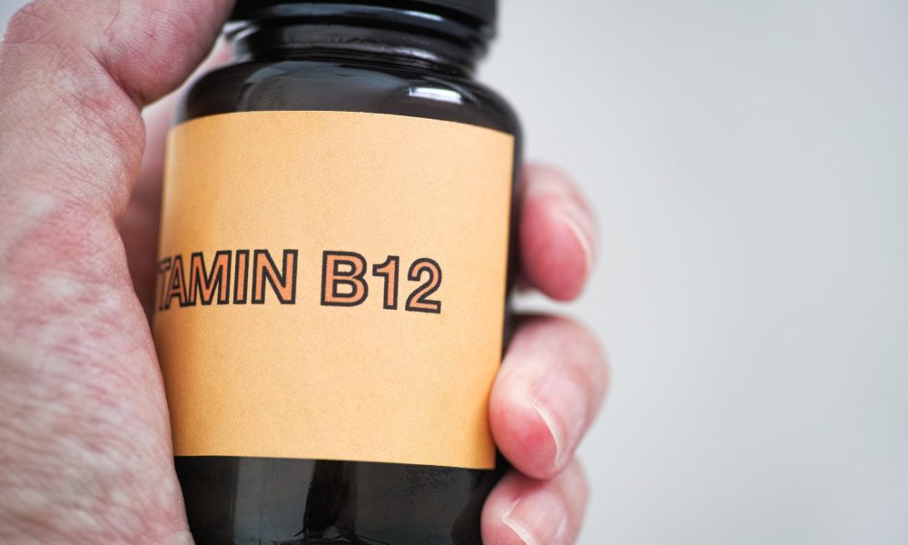 A man holding Vitamin B12 written medicine bottle | The Importance of Vitamin B12 | Hydription in Torrance, CA